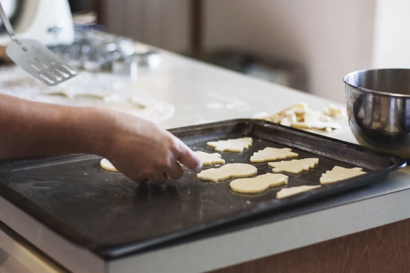 Cookies being placed onto a baking tray by hand